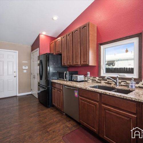 The spacious galley kitchen is fitted with a refrigerator, stove, dishwasher, microwave, toaster, coffee maker, and more!