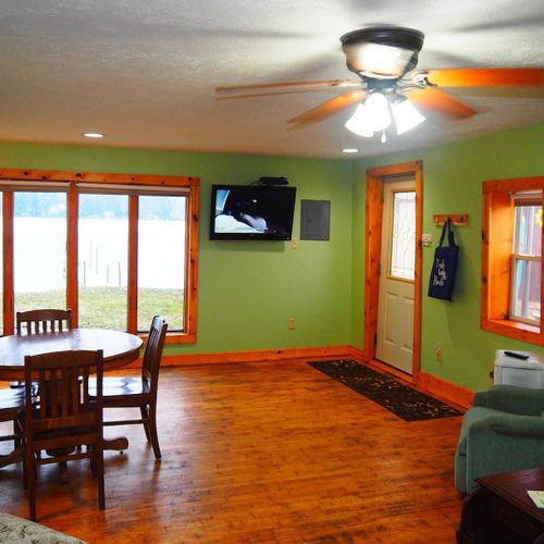 Living room and dining area:  very cute and cozy living room and dining area with a sofa, comfy chairs, dining table and chairs for 4 adults, ceiling fan, television with satellite tv, and a great view of turk lake!