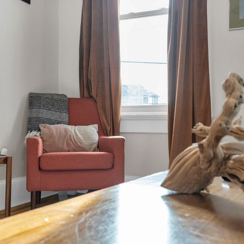 Snug armchair tucked in a warm corner — the perfect spot to curl up & get lost in a book.