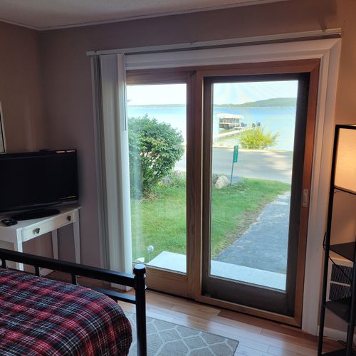 BEDROOM #2 (FIRST FLOOR):  Features a full-size bed, desk, streaming television, closet, private entrance, and a great view of Crystal Lake!