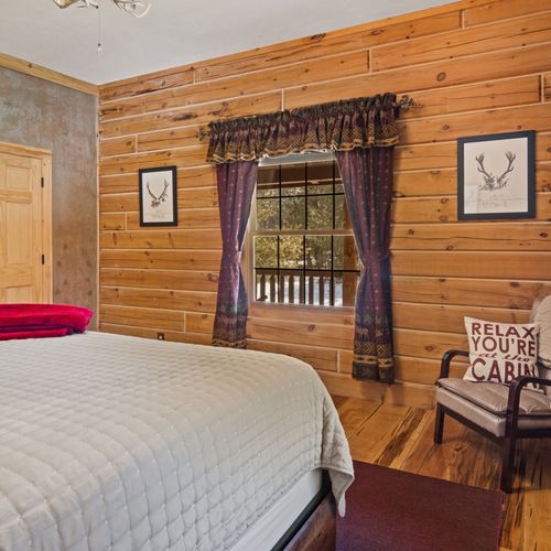 Bedroom #1 (main floor):  features a king-size bed, closet, and chair.