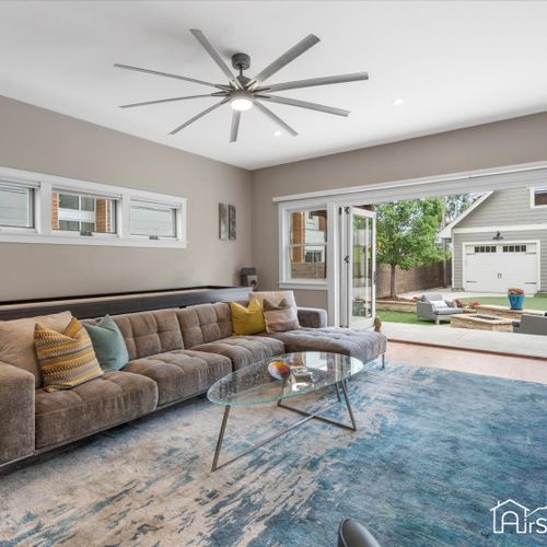 Enjoy indoor/outdoor living with a tri-panel accordion door opening to a backyard oasis.