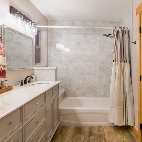 The master bedroom holds a private ensuite fitted with floor to ceiling marble textured tile