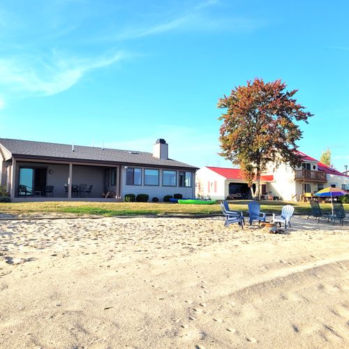 EXTERIOR:  A broader view of the private beach, private bonfire ring, and the house