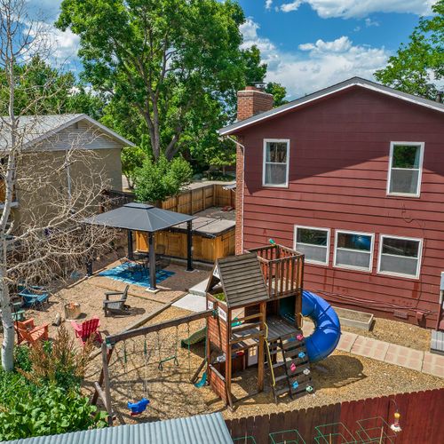 The backyard view reveals a sprawling landscape featuring a jungle gym and expansive yard, perfect for play and outdoor activities.