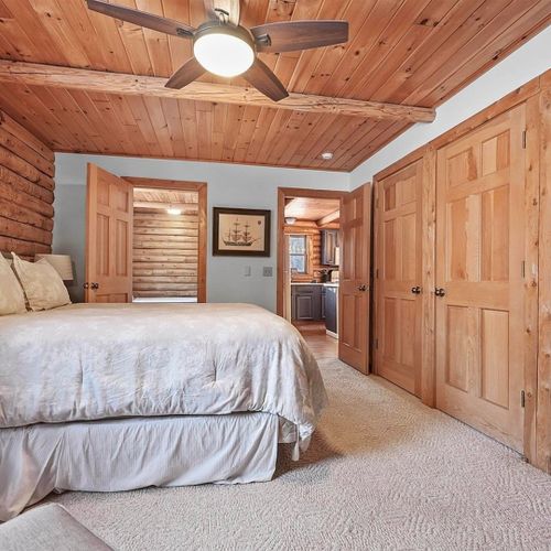Bedroom #1 (main floor):  features a queen-size bed, chair, nightstand, closet, ceiling fan, and private bathroom entrance.
