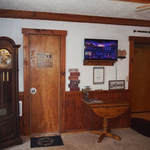 Living room:  includes a sofa, comfy chairs, live-streaming television, and entrance out to the deck.