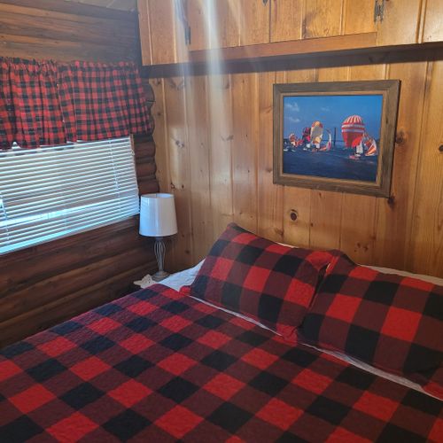 Bedroom #1:  features a queen-size bed, nightstand, lamp, mirror, dresser, and clothes rack.