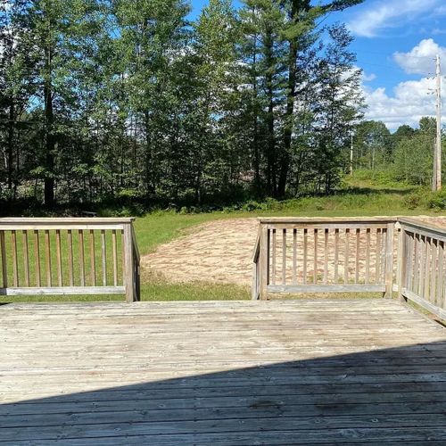 Exterior:  part of the huge deck, with the volleyball / badminton court in the background.