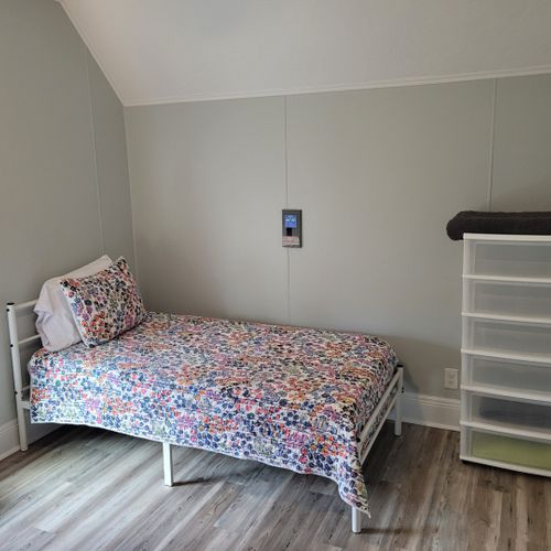 Bedroom #4 (second floor):  features a queen-size bed, twin bed, window a/c unit, ceiling fan, nightstand, lamp, dresser, and a closet.
