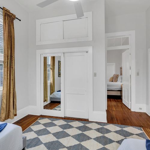 Bright and inviting twin bedroom with stylish bedding and ample natural light. This room offers a comfortable setup, perfect for friends or family members to unwind and enjoy a restful stay in New Orleans.