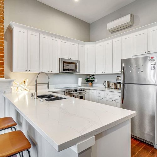Bright white kitchen w/ bar area — great for cooking in or grabbing a quick bite.