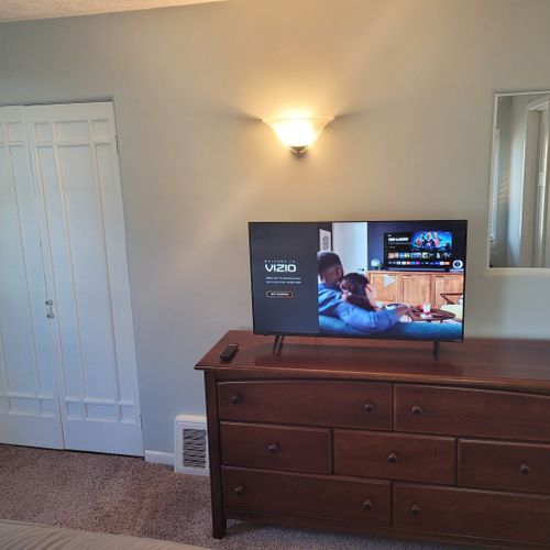 Bedroom #1:  features a queen-size bed, private en suite full bathroom, private television, walk-in closet, dresser, mirror, nightstands, and lamps