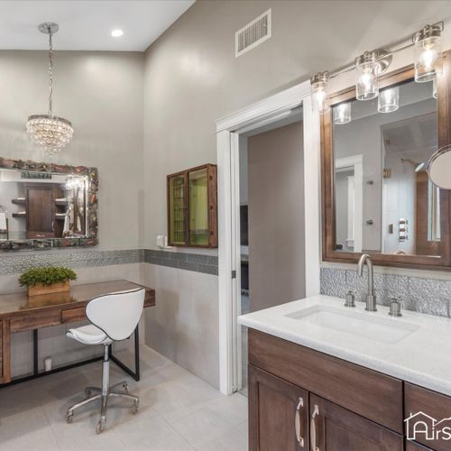 The master bathroom features a separate seated vanity area, providing a dedicated space for personal grooming.