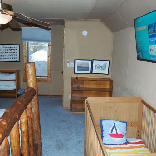 Bedroom #4 (second floor):  features a queen-size bed, private television, sofa bed, comfy chair, ceiling fan, baby crib, and a dresser.