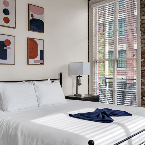 Airy bedroom bathed in natural light w/ crisp white bedding.