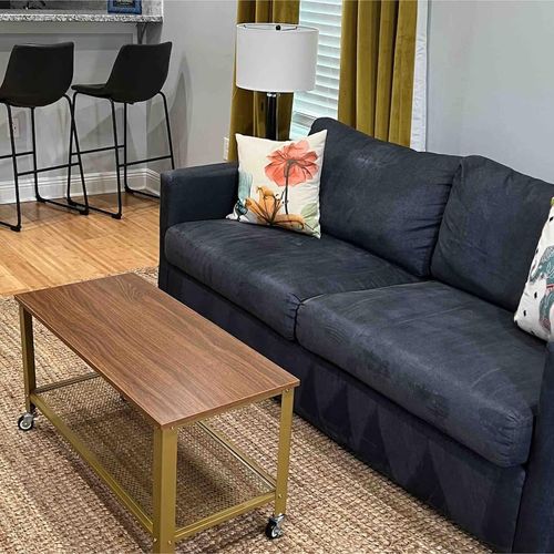 Cozy living room w/ plush sofa & wood coffee table — perfect for unwinding after a long day.
