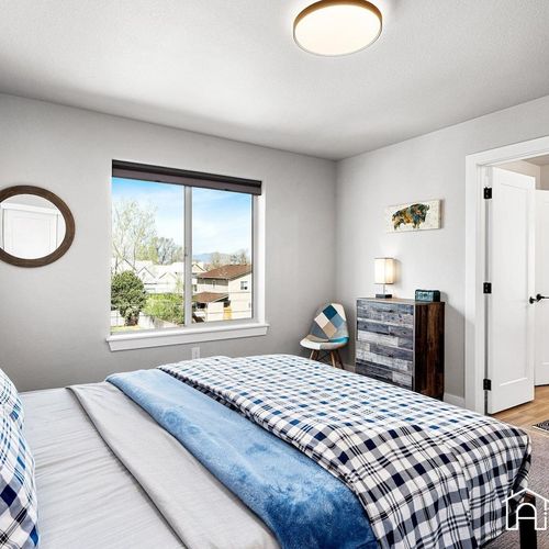 - cozy plaid bedding and soft lighting make this bedroom a warm and inviting retreat
- modern dresser and reading nook chair offer style and function for longer stays
- large window brings in morning light and views of the quiet street