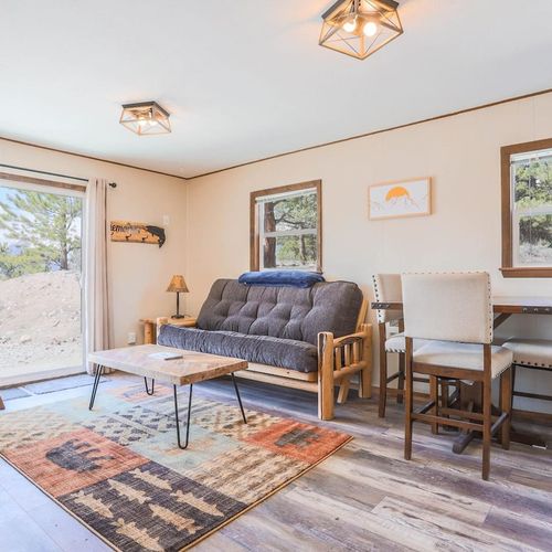 - comfortable futon and armchair create a relaxing space to unwind after outdoor fun
- warm wood accents and soft lighting enhance the cabin inspired ambiance
- sliding doors open to peaceful forest views and plenty of natural light