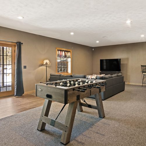 Lower level:  great family space in the lower level with dining table, wet bar, games, sofa, and television.