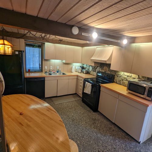 Kitchen:  the kitchen with all the basic cooking appliances including a dishwasher and coffeemaker along with a wooden table and stools