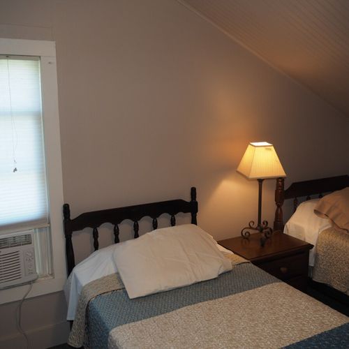 Bedroom #2:  features 2 twin beds, window a/c unit, nightstand, lamp, and mirror.