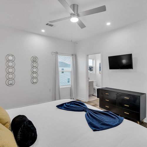 Unwind in this chic bedroom featuring a plush king bed, stylish decor, and a private bathroom. Relax with your favorite show on the wall-mounted TV, perfect for your stay in New Orleans.