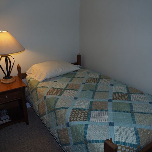Bedroom #2:  features two twin beds, a nightstand, lamp, dresser, mirror, and closet.