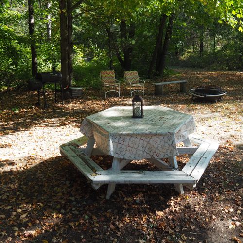 Exterior:  the private backyard with dining table, bonfire ring, grill, and chairs.
