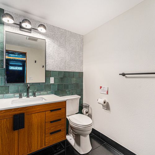 Step into the stunning basement bathroom adorned with ocean-colored tiled walls, evoking a serene and coastal ambiance.