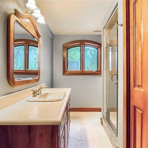 The full bathroom located downstairs is thoughtfully designed with a walk-in shower for convenience and accessibility.