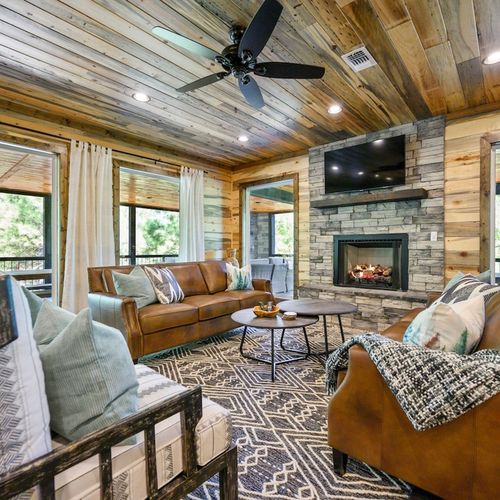 The living room with matching sofas and lounge seating around the fireplace.