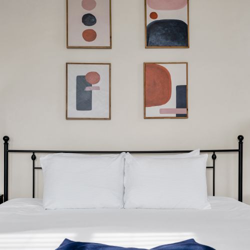 Classic black bed frame w/ curated wall art for a stylish night's sleep.