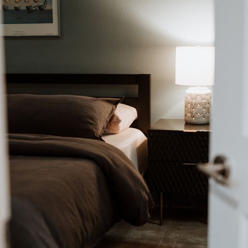 This king bedroom offers a cozy ambiance and thoughtfully curated private retreat off of the basement living room.