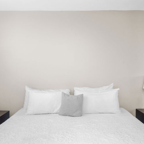 Spacious bedroom with ample natural light and a king-sized bed, perfect for relaxation and privacy.