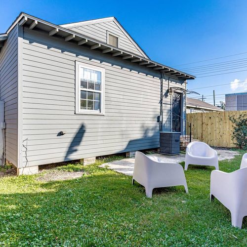 Lush backyard w/ lounge chairs — a peaceful outdoor retreat to relax & unwind.