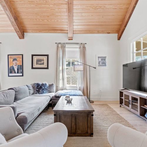 Bright living room w/ large couch & two chairs — plenty of seating for the whole group.