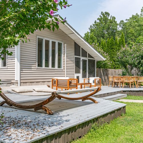 Step onto the back deck from the Three Seasons Room, conveniently located on the right side of the house, just behind the outdoor dinning table.