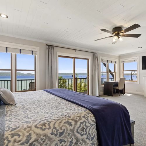 PRIMARY BEDROOM (UPPER LEVEL):  The home has a truly spectacular primary bedroom on the upper level with a king-size bed, private balcony, incredible view of Crystal Lake, private ensuite bathroom, gas fireplace, and private television.