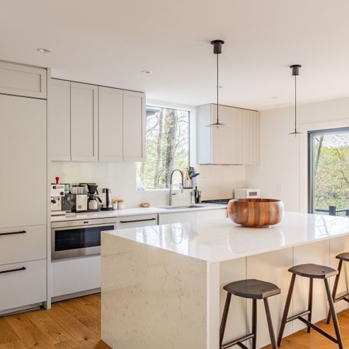 This spacious kitchen features an expansive island and sliding doors leading to the grill and outdoor dining area.