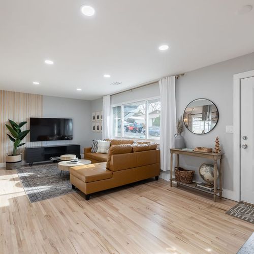 - catch your favorite shows on the flat screen tv framed by minimalist wood accents
- plush sectional and relax in a sunlit space perfect for lazy mornings or cozy nights
- chic console table, greenery, and globe decor bring travel inspiration to lif