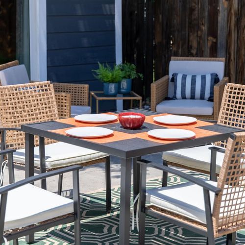 - outdoor patio includes a modern dining table set for four and cushioned lounge seating
- black metal frames and woven rattan chairs blend comfort with style
- perfect for al fresco meals, morning coffee, or casual evening hangouts