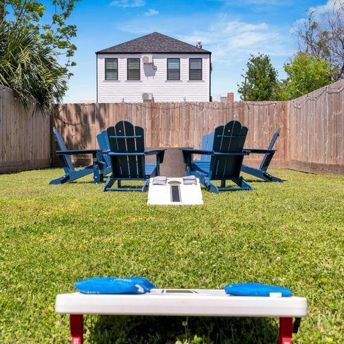Blue Adirondack chairs, cornhole & open sky — your backyard hangout awaits.