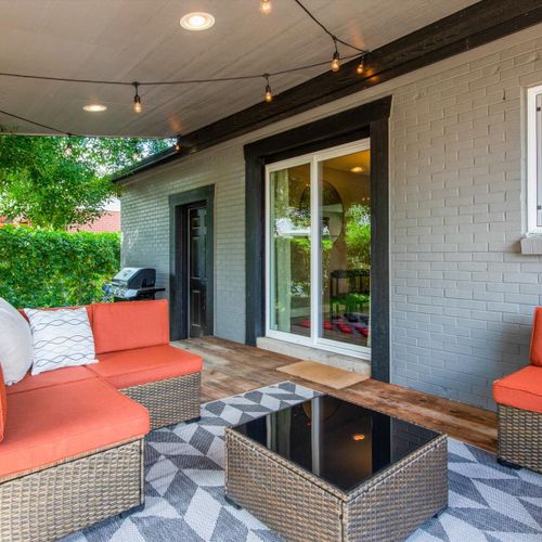 Enjoy the lovely weather on the covered patio featuring a cozy sectional, giant checkers, ambient string lighting and a propane grill.