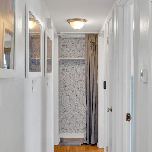 Art-filled and inviting, this charming hallway leads you to more of the home’s thoughtful details and cozy spaces. Every corner tells a story!