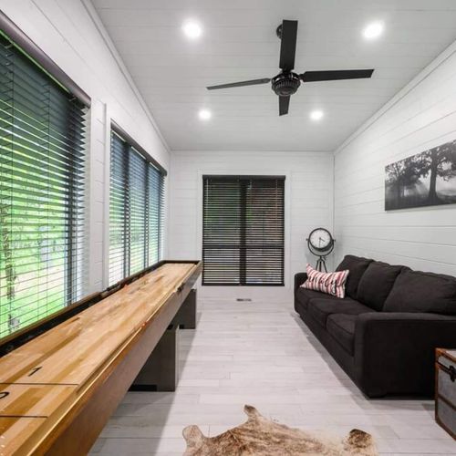 A game room featuring shuffleboard as well as a sleeper sofa.
