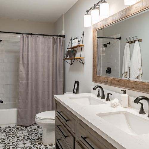 Full bathroom with tub and double sinks