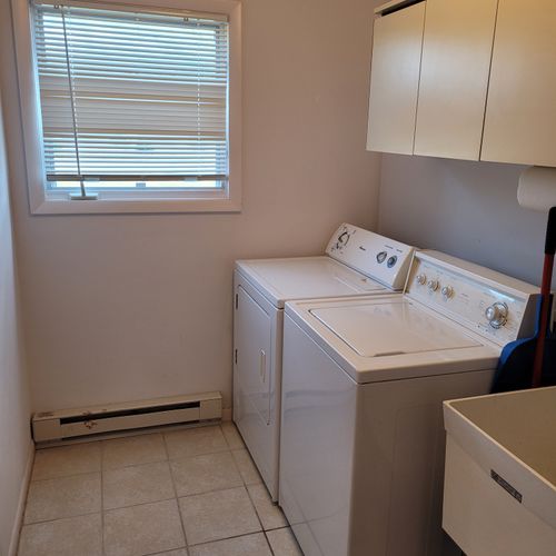 LAUNDRY ROOM (FIRST FLOOR):  Very convenient main floor laundry room with washer, dryer, sink, and table.