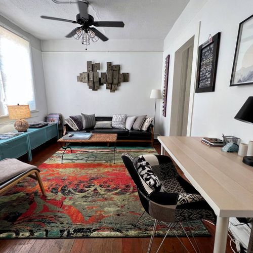 Light-filled living room w/ colorful rug & cozy seating — perfect for unwinding after a day out.