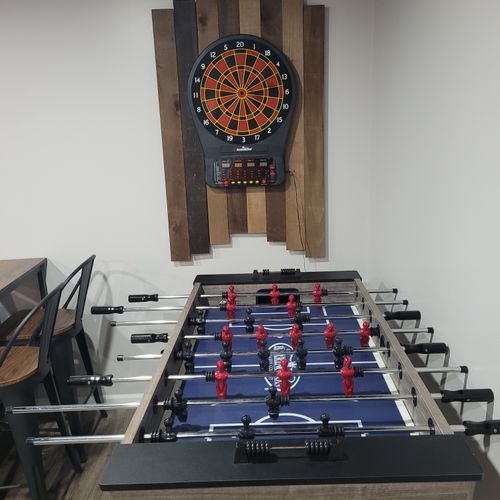 LOWER LEVEL:  Fully finished lower level with multiple sofas, multiple televisions, a foosball table, dartboard, and an air hockey table.